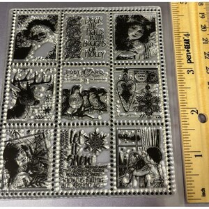 May include: Clear, rectangular stamp set featuring various winter-themed designs. Includes images of a deer, birds, angels, and children, along with text that reads "Deck the halls with boughs of holly" and "Let it snow". The ruler next to the stamp set measures 3 inches.