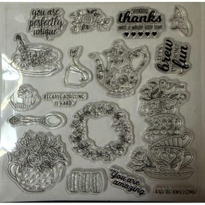 May include: A clear sheet of photopolymer stamps featuring black line art designs of a teapot, teacups, a floral wreath, a spoon, macarons, and tea bags. Text includes "you are perfectly unique," "sending thanks with a whole latte love," "let's brew up some fun," "because adulting is hard," "you are amazing," and "and be awesome."