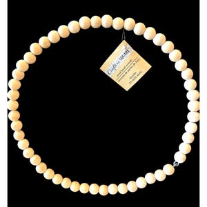 May include: A natural wood bead wreath, 10 inches in diameter, for crafting projects. The wreath is made of unfinished wood beads and is ready to be painted or stained.