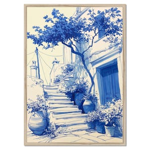 May include: A framed wall art print featuring a blue and cream ink-style illustration of a Mediterranean street scene. The image depicts stone stairs leading up to a blue door, surrounded by potted plants and a large tree under a clear sky.