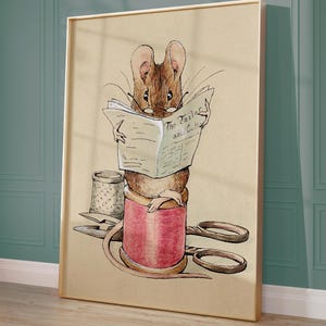 May include: Framed print of a brown mouse reading a newspaper titled "The Tailor and Cutter." The mouse wears glasses and sits on a red thread spool. A thimble and scissors are also visible. The artwork has a vintage, storybook style, with a beige background.