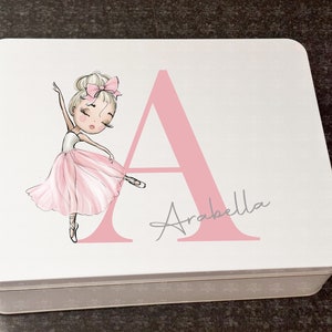 May include: A white metal tin featuring a pink ballerina illustration and the letter "A" in pink. The name "Arabella" is written in grey script below the letter.