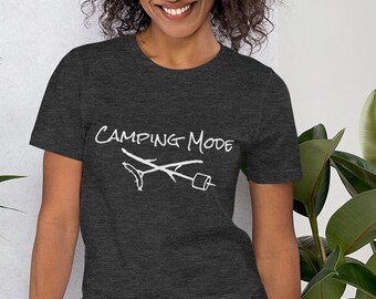 May include: A dark heather grey t-shirt with a white graphic of crossed sticks and a marshmallow. The text "Camping Mode" is written above the graphic.