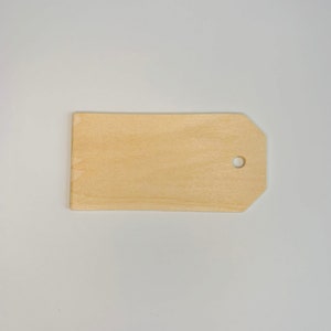 May include: A plain wooden tag with a hole in the top, perfect for adding a personal touch to gifts or crafts.