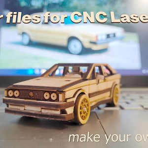 Puede incluir: Un rompecabezas de coche de madera de un coche antiguo, con el texto "make your own puzzle" debajo. El modelo está sentado en un teclado de portátil, con una imagen borrosa de un coche similar en el fondo. El texto "Vector files for CNC Lasers." está en la parte superior de la imagen.