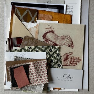 May include: A collection of various paper and fabric samples, including patterned and textured pieces. A sketch of hands is visible, along with a business card that reads "OLGASABODE". The color palette includes beige, brown, red, and green.