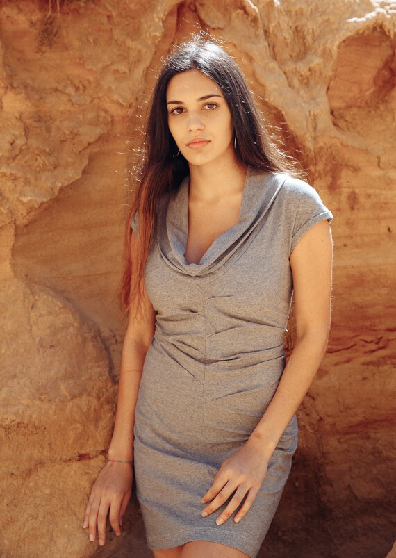 Knitted cowl neckline fitted dress. Tucks through centre front panel line and dropped capped sleeves. Knitted cowl neckline fitted dress. Tucks through centre front panel line and dropped capped sleeves.