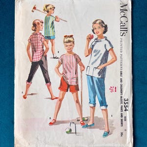 Op de afbeelding: Vintage McCall's naaipatroon met illustraties van meisjeskleding, waaronder blouses, broeken en shorts. De omslag heeft een retro-ontwerp met het nummer 3554 en de prijs 2/6.