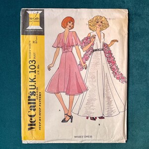 May include: A vintage McCall's sewing pattern for a misses' dress. The pattern is for a dress with a V-neckline and a flowing skirt. The pattern number is McCall's U.K. 103, and the size is misses' size 6, bust 36 inches (97 cm).