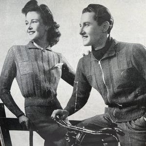 Puede incluir: Fotografía vintage en blanco y negro de un hombre y una mujer con suéteres de punto con cremallera a juego. La mujer se apoya en una valla de madera y el hombre está sentado en una bicicleta. Los suéteres tienen un diseño acanalado y bolsillos.