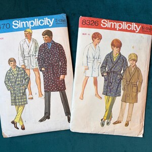 May include: Two vintage Simplicity sewing pattern envelopes. One is labelled 8470, the other 8326. The patterns show illustrations of robes in various styles and colours. The background is a dark teal.