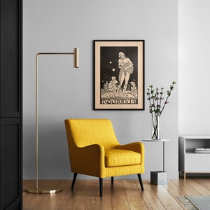 May include: A black and white illustration of the zodiac sign Aquarius, framed in black, hanging on a white wall above a yellow armchair. The illustration depicts a figure pouring water from a jar.