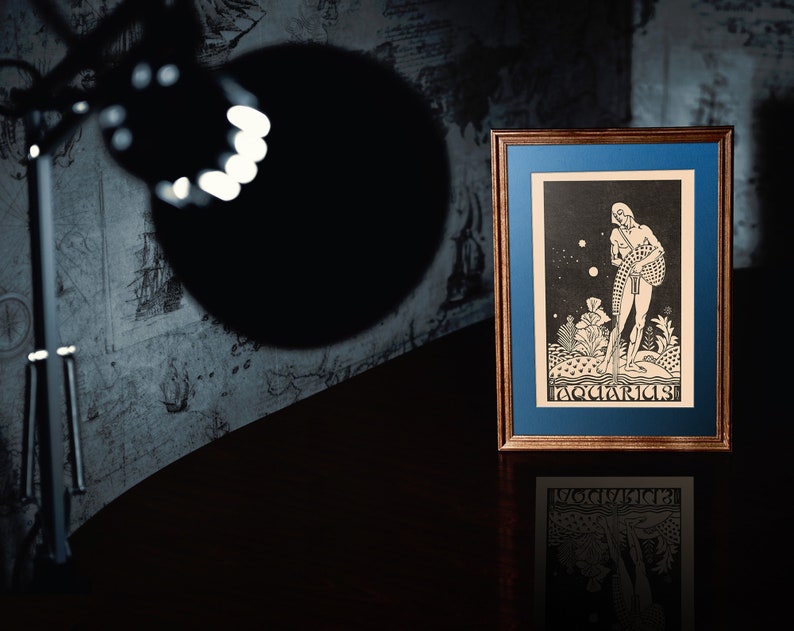May include: A framed black and white print of an astrological illustration of Aquarius. The image depicts a figure standing in a field of flowers with stars in the background. The text "Aquarius" is printed at the bottom of the image.