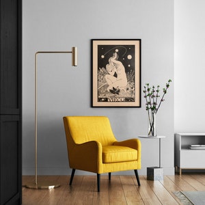 Puede incluir: Un p&oacute;ster enmarcado en negro con una ilustraci&oacute;n en blanco y negro de una mujer sentada con una estrella sobre su cabeza. El p&oacute;ster tiene la palabra "VIRGO" impresa en la parte inferior. El p&oacute;ster est&aacute; colgado en una pared blanca sobre un sill&oacute;n amarillo.