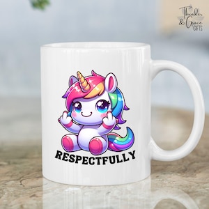 May include: White ceramic mug featuring a cartoon unicorn with a rainbow mane and tail, giving the middle finger. The word "RESPECTFULLY" is printed below the unicorn. The mug has a curved handle and the text "Thunder & Grace GIFTS" is on the right side.