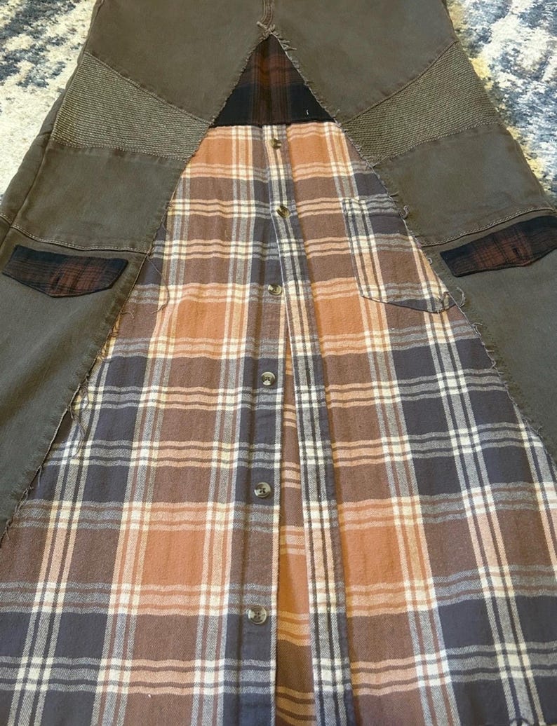 May include: A unique garment featuring a combination of brown denim and a plaid flannel shirt. The denim sections have textured patches and pockets. The flannel has a button-up design with a mix of brown, orange, and white plaid.
