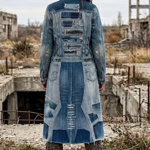 May include: A long denim coat featuring a patchwork design with various shades of blue fabric, distressed edges, and multiple horizontal stitched panels on the back. The garment includes integrated pocket details and visible seams throughout the construction.