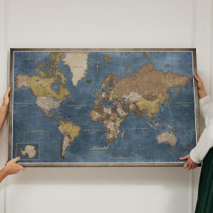 Op de afbeelding: Een wereldkaart met een vintage uitstraling. De kaart heeft een blauwe oceaanachtergrond met bruine en beige continenten. Het woord "World" staat op de kaart. De kaart wordt door twee personen vastgehouden.