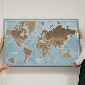 Peut inclure: Une carte du monde encadrée, avec des continents bruns et des océans bleus. La carte comprend les noms des océans et une rose des vents. Le texte "the World" est en bas. Le cadre est bleu.