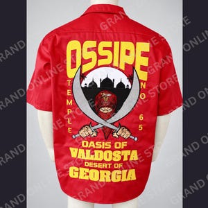 May include: A bright red short-sleeved button-down shirt featuring a large back graphic. The design includes yellow text reading OSSIPE TEMPLE NO 65, OASIS OF VALDOSTA, DESERT OF GEORGIA, and an illustration of a masked figure holding two crossed scimitars.
