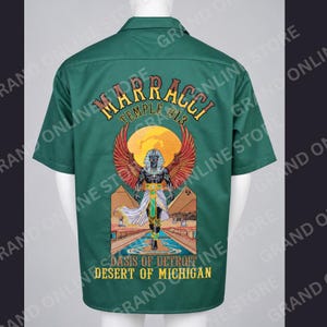 May include: A dark green short-sleeve button-up shirt featuring a back graphic of an Egyptian-style figure with wings, pyramids, and a sun. The text reads MARRACCI TEMPLE #13 OASIS OF DETROIT DESERT OF MICHIGAN in yellow and orange lettering.
