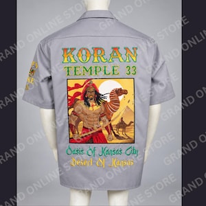 May include: A grey short-sleeve button-up shirt featuring a back graphic of a figure with a sword and a camel in a desert setting. Text reads KORAN TEMPLE 33, Oasis of Kansas City, and Desert of Kansas. A small emblem is visible on the left sleeve.