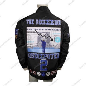 Könnte beinhalten: Schwarze Jacke mit einem Grafikdruck eines Dollarscheins mit einem Abwärtstrendpfeil und dem Text "THE RECEΣΣΙΟΝ" und "UNDISPUTED 2".