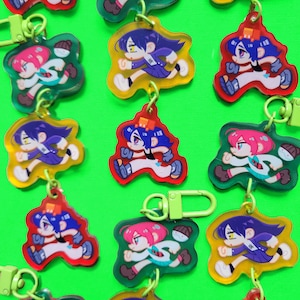 May include: A collection of colorful acrylic keychains featuring a running cartoon character. The keychains have a variety of background colors, including green, yellow, and red. Each keychain has a metal clasp for easy attachment.