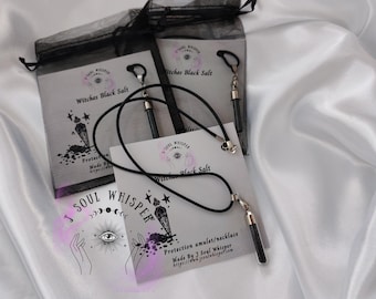 May include: A black cord necklace with a small, clear glass vial pendant filled with black salt. The necklace is displayed on a white card labeled Witches Black Salt and J Soul Whisper, featuring an illustration of an eye and stars.