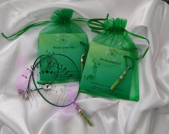 May include: Two green organza drawstring bags containing cards labeled Witches Green Salt, each paired with a green cord necklace featuring a small, clear cylindrical pendant filled with green salt crystals and silver-toned metal caps.