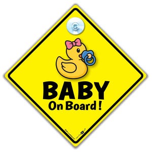 Könnte beinhalten: Gelbes rautenförmiges "Baby an Bord"-Schild mit einer Cartoon-Ente mit rosa Schleife und blauem Schnuller. Das Schild hat einen Saugnapf zur Befestigung an der Autoscheibe.