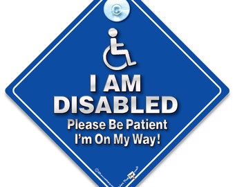 May include: Blue diamond-shaped car sign with a white border. The sign has a silver wheelchair symbol and the text "I AM DISABLED Please Be Patient I'm On My Way!"