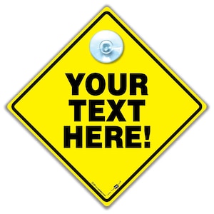 Könnte beinhalten: Ein gelbes rautenförmiges Schild mit schwarzem Rand und dem Text "YOUR TEXT HERE!" in fetten schwarzen Buchstaben. Oben ist ein durchsichtiger Saugnapf angebracht. Das Schild ist anpassbar.