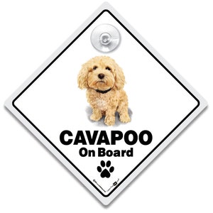 Może przedstawiać: Biały, diamentowy znak samochodowy z przyssawką na górze. Znak zawiera kreskówkową ilustrację jasnobrązowego psa rasy Cavapoo z czarnymi oczami i czarnym kołnierzem. Tekst "CAVAPOO On Board" jest wydrukowany czarnym kolorem pod psem. Czarny ślad łapy znajduje się pod tekstem.