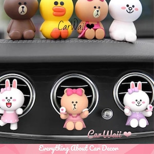 May include: A set of six car air vent clips featuring popular cartoon characters. The characters are brown bears, a yellow duck, a white bunny, and a pink bunny. The characters are wearing pink dresses and have bows in their hair. The characters are all smiling and have big eyes. The air vent clips are made of plastic and are designed to fit most car air vents.  CarWaii Everything About Car Decor