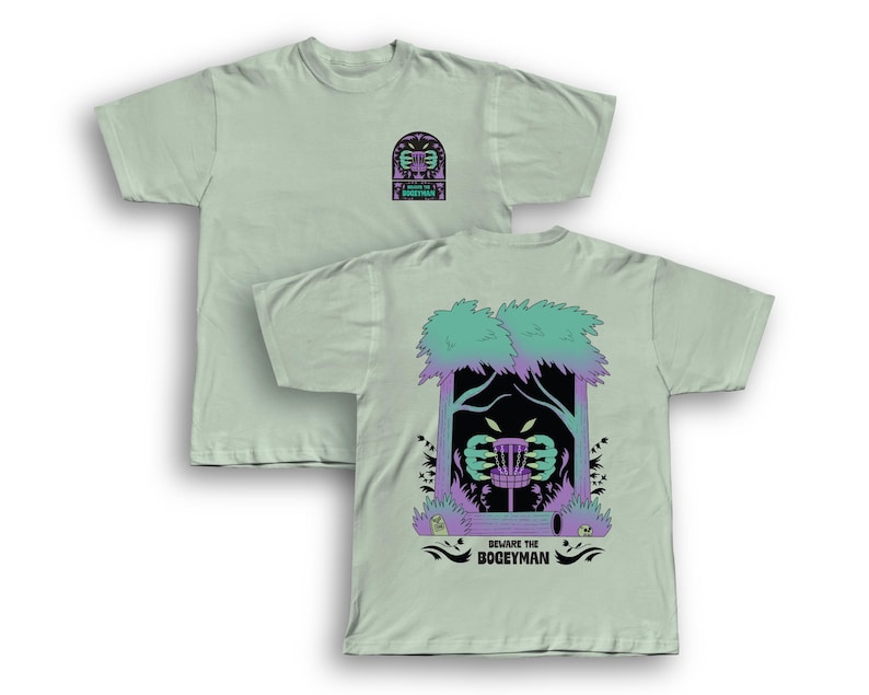 Puede incluir: Dos camisetas verde claro. Una camiseta tiene un peque&ntilde;o gr&aacute;fico en la parte delantera. La otra camiseta tiene un gr&aacute;fico m&aacute;s grande en la parte posterior con una canasta de disc golf, &aacute;rboles y el texto "Beware the Boogeyman."