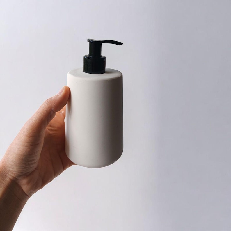 May include: White ceramic soap dispenser with a black pump top.