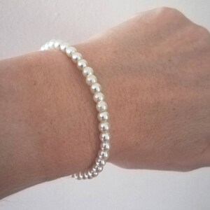 May include: A simple white pearl bracelet.