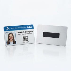 May include: A rectangular name badge featuring a blue and white header with the text Apex Innovations Group and AIG. It displays a photograph of a person, the name Daniela A. Thompson, the title SENIOR TECHNICAL ENGINEER, a QR code, and a number.