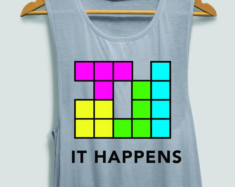 May include: A light blue tank top with a colourful block design and the text "IT HAPPENS".