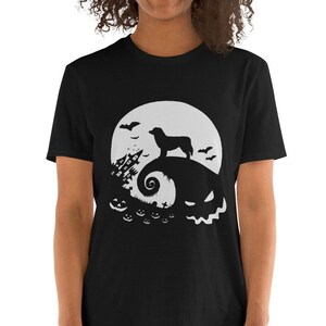 May include: Black t-shirt with a white silhouette of a dog standing on a hill with a moon and bats in the background. The hill is shaped like a jack-o-lantern with a spooky face.