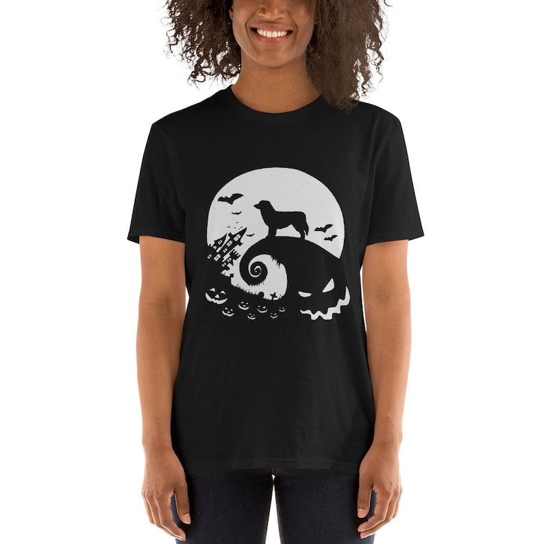 May include: Black t-shirt with a white silhouette of a dog standing on a hill with a moon and bats in the background. The hill is shaped like a jack-o-lantern with a spooky face.