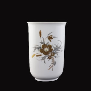 Könnte beinhalten: Eine weiße Keramikvase mit floralem Design. Die Blumen sind in Braun- und Goldtönen gehalten, mit grauen Blättern und Stielen. Die Vase hat eine glatte, glänzende Oberfläche und einen leicht ausgestellten Rand.