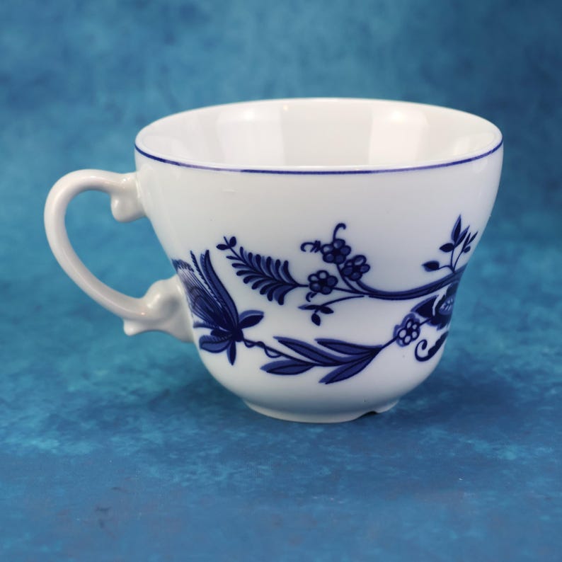 May include: A set of three ceramic mugs with a speckled, matte finish. The mugs are in shades of cream, light gray, and dark gray. Each mug has a simple, minimalist design, perfect for coffee or tea.