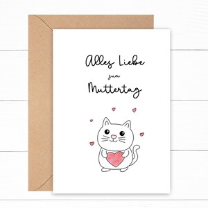 May include: A white card with the text "Alles Liebe zum Muttertag" and a cartoon white cat holding a pink heart. There are small pink hearts scattered around the cat.
