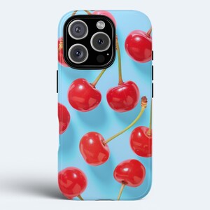 May include: A blue phone case with a pattern of red cherries. The case has a camera cutout and a black border.