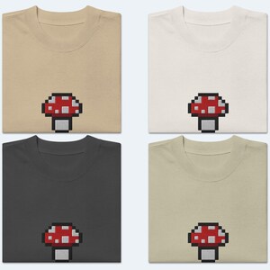 May include: Four t-shirts in different colors, each featuring a pixelated red and white mushroom graphic.