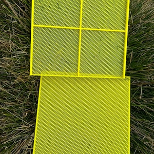 May include: Three yellow plastic square-shaped mesh screens. The screens are made of a fine mesh and are perfect for sifting or straining.