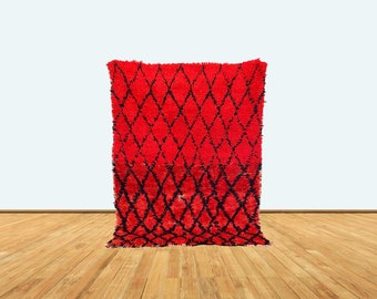 May include: A red and black Moroccan rug with a diamond pattern. The rug is made of wool and has a soft, fluffy texture.