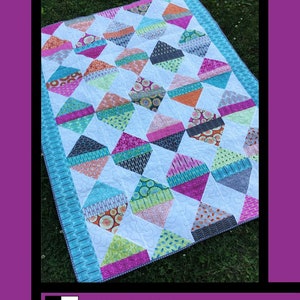 May include: Diamond Daze quilt pattern by Tricia Lynn Maloney for Villa Rosa Designs. The quilt features a colorful diamond pattern with a variety of fabrics in shades of pink, blue, green, and orange.